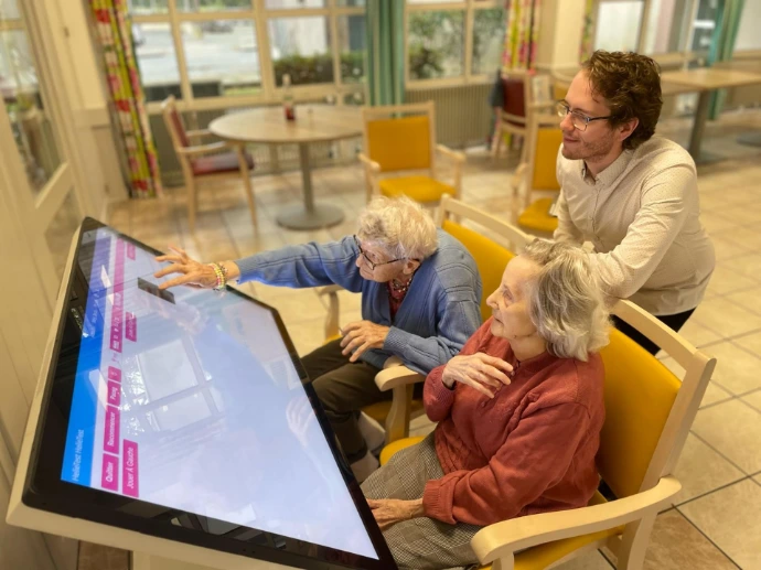 Deux personnes utilisant la table tactile